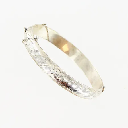 Stelt armband, innermått 60x55m öppningsbart, mönstrad ovansida, bredd 9mm, ihåligt, säkerhetskedja defekt, stämplad: sterling, silver 925/1000. Vikt: 13,6 g