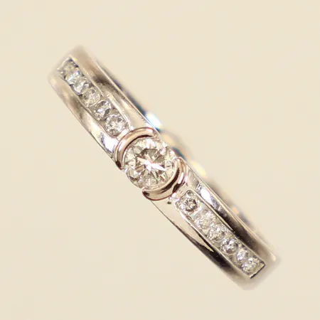 Ring med diamanter ca 1 x 0,16ct+ 12 x 0,01ct, stl 16¾, bredd ca 2-3,3mm, vitguld, gravyr, repig, Guldfynd, 18K Vikt: 2,8 g