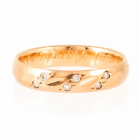 Ring i 18K guld med 6 x 0,01ct briljantslipade diamanter. Den är i storlek 17½, är 4 mm bred och väger 3,6g. Stämplad BÖS (Schalins Ringar, Östersund), 18K & kattfot. Stenstorlek ingraverad 0,06ct. Gravyr.