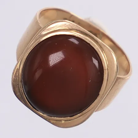 Ring med brun sten troligen karneol, stl ca 19, bredd 4-20mm, otydliga Finska stämplar, bucklig skena, sten något lös i fattning, 14K Bruttovikt: 6,4g Vikt: 6,4 g