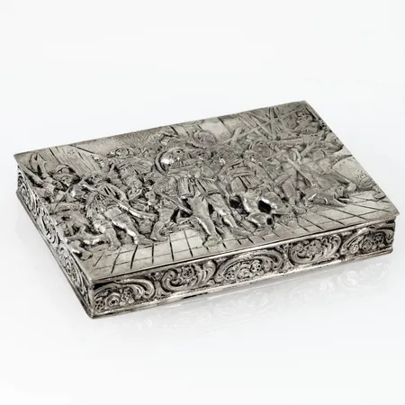 Lockask i silver med motiv från Rembrandts The Night Watch i relief. Den är 65 x 95 x 15 mm och väger 133,7g. Förgylld insida. Stämplad 830S & svenska importstämplar. Liten ojämnhet på undersidan. 