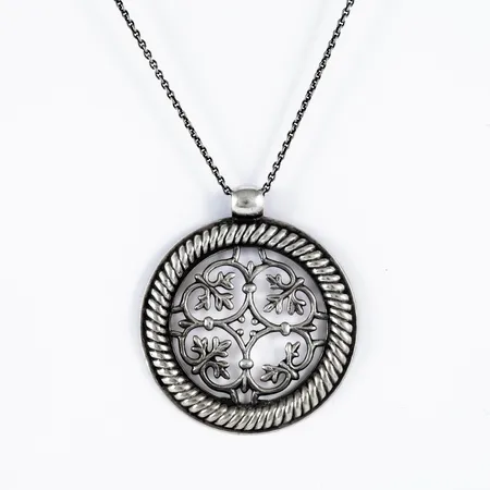 Hänge och kedja "Tuukkalan" i silver, Kalevala Koru, Finland. Hängets mått Ø 47 mm, kedjans längd 70cm. Vikt: 16,9g. Defekt, del av dekor borta.