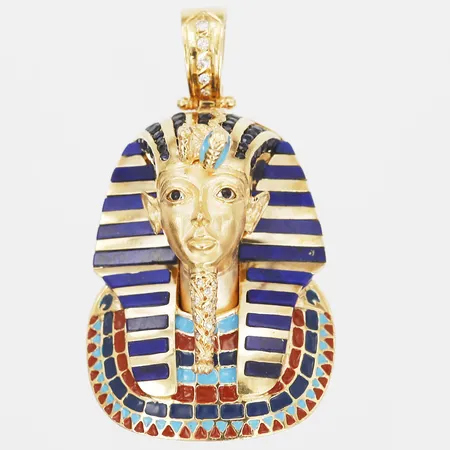 Hänge i form av Tutankhamon, med safirer, lapis lazuli, emalj samt diamanter, totalt ca 0,07ct, höjd 50mm, bredd 30mm, tillverkad av Orintio, Spanien, 18K guld Vikt: 33 g
