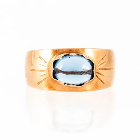 Doserad ring i 18K guld med blå cabochonslipad sten. Den är i storlek 16¼, är 4,2 - 8,4 mm bred och väger 2,1g. 18K & kattfot.