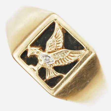 Klackring med örn på onyxplatta samt åttkantsslipad diamant ca 0,05ct, stl: 21, tillverkad av Guldfynd AB, 18K guld Vikt: 8 g