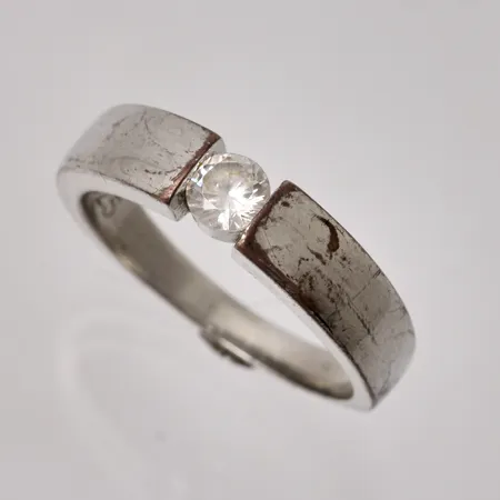 Ring i försilvrad metall, stl 18¼, bredd 2,8-4,9mm, 1st vit sten, mått Ø4,4mm, står 925S stämplat. Vikt: 0 g