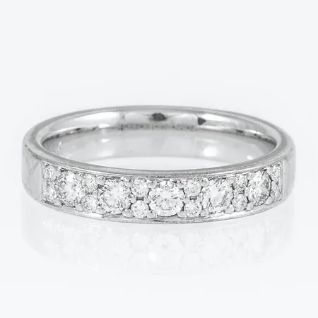 Ring i 18K vitguld med 5 x 0,07ct och 12 x 0,01ct (ca W/si). Den är i storlek 17, är 4 mm bred och väger 5,5g. Stenstorlek 0,47ct ingraverad. Stämplad SCH (Schalins Ringar, Östersund), 18K & kattfot.