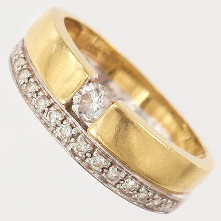 Ring med briljantslipade diamanter 1 x ca 0,15ct, 15 x ca 0,0075ct, stl: 17½, bredd 4,5-6,5mm, tvåfärgad, gravyr, 18K.  Vikt: 6 g