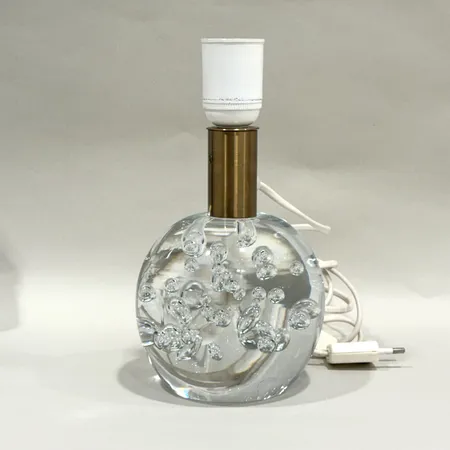 Bordslampa, Josef Frank för Firma Svenskt Tenn, Glasklotslampan, modell 1819, fot i klarglas med bubblor, Reijmyre glasbruk för Firma Svenskt Tenn, formgiven 1934, lampskärm modell Celotocaulis, mässingsfattning, höjd ca 22cm, Ø ca 11cm, bruksslitage, glas med repor, lampskärm med fläckar, ytslitage samt lätt skada, kontakt med lätt slitage, glödlampa saknas Skickas med postpaket.