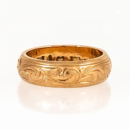 Ring i 18K guld med utvändig mönstergravyr. Den är i storlek 17¾, är 6 mm bred och väger 9,3g. Stämplad M9 (1962), HAÖ (Öhmans Eftr P Aug, Lycksele), 18K & kattfot. Gravyr. 