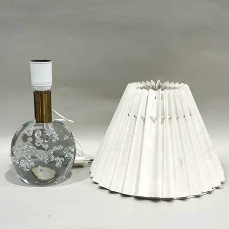 Bordslampa, Josef Frank för Firma Svenskt Tenn, Glasklotslampan, modell 1819, fot i klarglas med bubblor, Reijmyre glasbruk för Firma Svenskt Tenn, formgiven 1934, lampskärm modell Celotocaulis, mässingsfattning, höjd ca 22cm, Ø ca 11cm, bruksslitage, glas med repor, lampskärm med fläckar, ytslitage samt lätt skada, kontakt med lätt slitage, glödlampa saknas Skickas med postpaket.