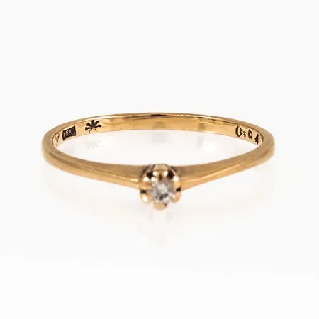 Ring i 18K guld med en diamant 0,04ct.  Den är Ø 16¼, 1,3 - 3,2 mm bred och väger 1,4g. Stenstorleken & Stjärnringens stjärna. 