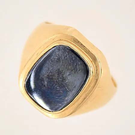 Klackring med hematit, stl 17¼, bredd 3-15mm, sten samt skena med mindre repor, gravyr, 18K  Vikt: 4,7 g