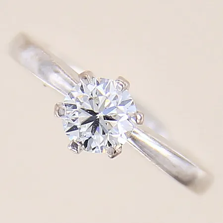Ring med diamant 0,75ct, kvalitet W(H)/SI enligt gravyr, inneslutningar samt fjädrar som når ytan, stl 15¼, bredd 2-7mm, vitguld, 18K  Vikt: 4,2 g