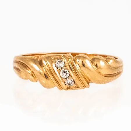 Ring i 18K guld med 3 x 0,02ct briljantslipade diamanter. Den är i storlek 18¼, är 2 - 6,6 mm bred och väger 3,6g. Stenstorlek 0,06ct ingraverat. Stämplad Q10 (1990), BEH (Bengt Hallberg, Köping), 18K & kattfot. 