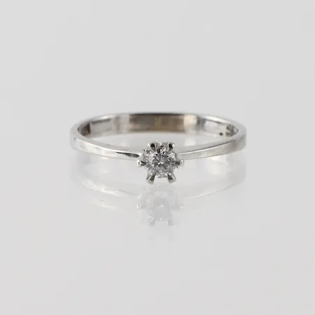 Ring vitguld med solitär diamant på 0.14 ct enligt inskription, storlek 17 ¼ mm, bredd 2.4-4.8 mm, 18k. Vikt: 2,1 g