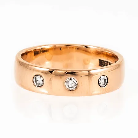 Ring i 18K guld med 3 x 0,05ct briljantslipade diamanter i lordfattning. Den är i storlek 17, är 4,8 mm bred och väger 5,4g. Stämplad GBA (Guldbolaget, Bergkvara), Stenstorlek, 18K & Kattfot. 