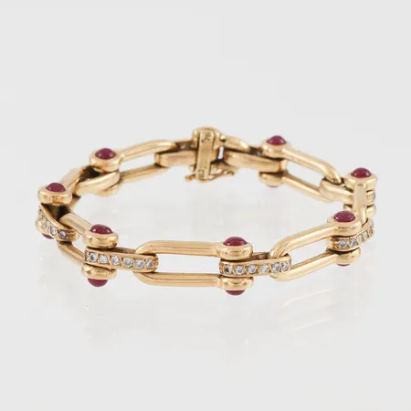Armband med diamanter 56 st x ca 0.02 ct och 14 st rubiner med cabochonslipning, längd ca 18 cm, bredd ca 7.9 mm, 18k. Vikt: 39,5 g