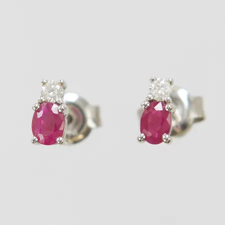 Ett par örhängen, rubiner samt briljantslipade diamanter 2 x ca 0,03ct, ca 6 x 3mm, vitguld, 9K Vikt: 0,8 g