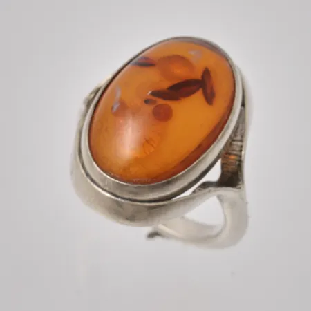 Ring i silver, stl 16¾, bredd 2,9-24,2mm, 1st bärnsten, mått 15x21mm, 830/1000, vikt 7,39g.
