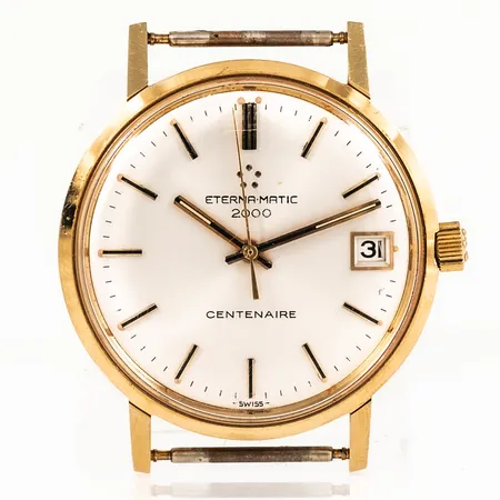 Herrur ETERNA MATIC 2000 CENTENAIRE i 18K guld utan band. Boett Ø 34,5 mm med namngravyr bak. Boett no 6106619. Automat. Smårepigt plastglas. Bruttovikt 31,3g.