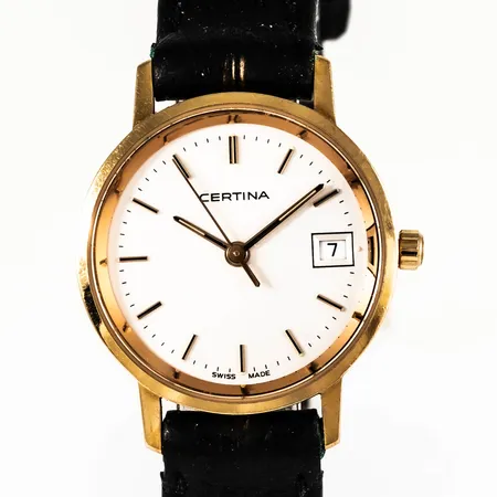 Damur Certina i 18K guld. Boett Ø 24 mm, safirglas, datum, quartz. Gravyr "Umeå Kommuns Hedersgåva". Går ej - batteribyte krävs? Defekt originalband i svart läder. Bruttovikt: 16,7g.