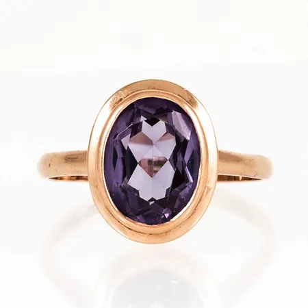 Ring i 14K guld med lila sten. Den är i storlek 21, är 2,2 - 15,6 mm bred och väger 4,3g. Finska stämplar. Något lös sten.