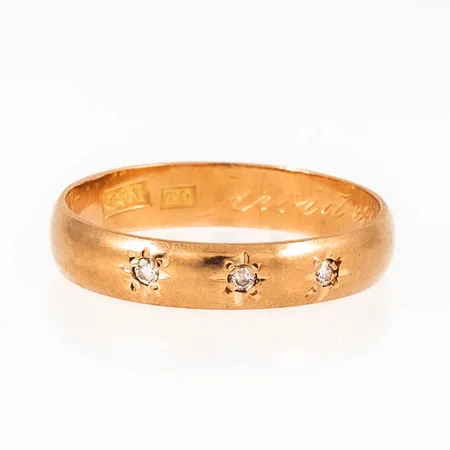 Ring i 18K guld med 3 x ca 0,01ct briljantslipade diamanter fattade i stjärnstick. Den är i storlek 19, är 4 mm bred och väger 3,2g. 18K & kattfot. Gravyr. 