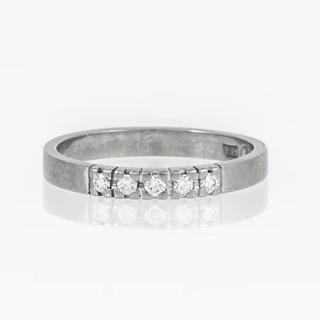 Stjärnring "Fenix" i 18K vitguld med 5 briljantslipade diamanter á 0,02ct Tw/si. Den är i storlek 17, är 2,5 mm bred och väger 2,9g. Stenstorlek 0,20ct ingraverad. Stämplad Stjärnringenstjärna, F10 (1980), HS (Hans Strömdahl, Stockholm), 18K & kattfot.
