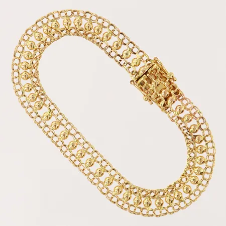 Armband, längd 16,5cm, bredd 7,5mm, skev/något bucklig, 18K.  Vikt: 6,6 g