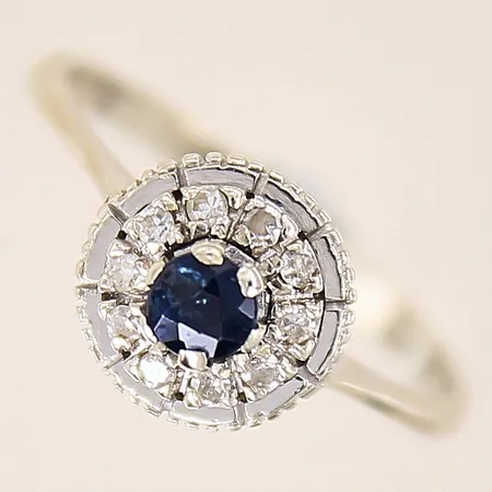Ring med diamanter 10 x ca 0,01ct samt safir, stl 18, bredd 2-10mm, vitguld, safir med nagg, i behov av omrodiering, 18K  Vikt: 3,4 g