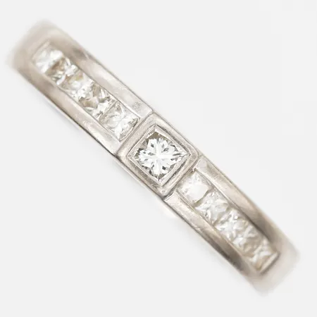 Ring med prinsesslipade diamanter 10 x ca 0,04ct, 1 x ca 0,10ct, stl: 18½, bredd: 3-4mm, GHA, gravyr, smärre bruksslitage, 18K vitguld. Vikt: 4,5 g