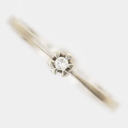 Ring med diamant 1 x ca 0,002ct, stl: 16, bredd: 2-3mm, 18K vitguld.  Vikt: 1,6 g