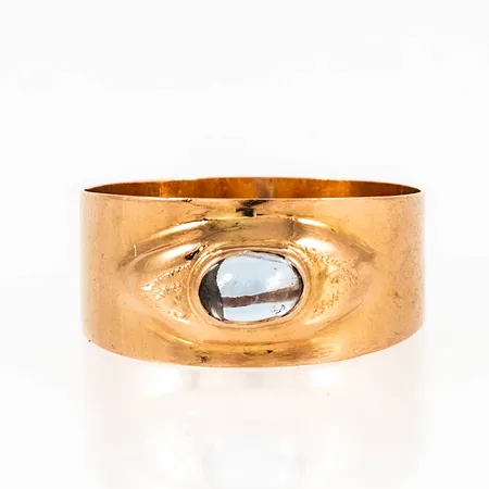 Doserad ring i 18K guld med ljusblå sten. Den är i storlek 17½, är 5,2 - 8,7 mm bred och väger 1,8g. Stämplad PW (Fritz Olsson i Skellefteå), H9 (1958) & 18K.