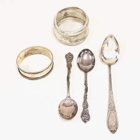 2 servettringar, 2 kaffeskedar, 1 tesked, defekter, gravyrer, silver 830/1000. Vikt: 53 g