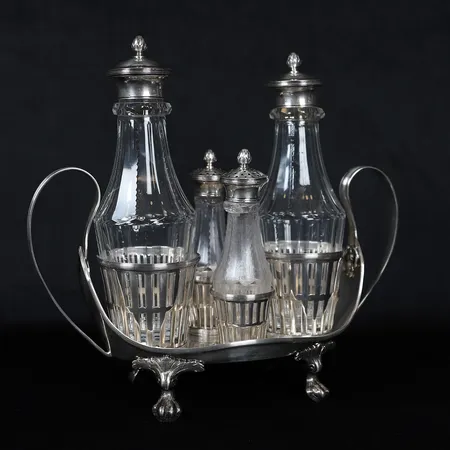 Bordssurtout i sengustaviansk stil, fasetterade glasflaskor samt ströare med lock, ställ 27x11cm & flaskor 19,5x6,8cm respektive 13x3,8cm, Anders Fredrik Weise (1776-1808), Stockholm år 1795, defekt dekor på hals av ströare, åldersbetingat slitage, silver. Vikt: 1464 g