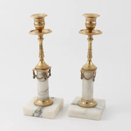Ljusstakar paret,Sengustavianska ca år 1800,marmor  och förgylld brons, möjligtvis utförda av FREDRIC LUDVIG RUNGS verkstad (hovciselör i Stockholm 1758-1837).En hängdekoration i kedjan saknas, kantslitage/naggar på marmorn, höjd ca 23 cm. Skickas med postpaket.