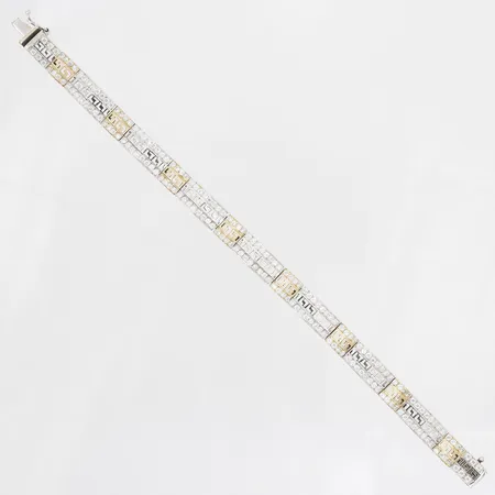 Armband med dekor av meanderbård samt vita stenar, längd ca 19,5cm, bredd 13mm, 14K vitguld Vikt: 21 g