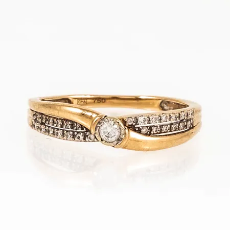 Ring i 18K guld med 1 x ca 0,05ct och 26 x ca 0,005ct briljantslipade diamanter. Den är i storlek 16+, är 1,4 - 4 mm bred och väger 2,1g. Stämplad GHA, 750.