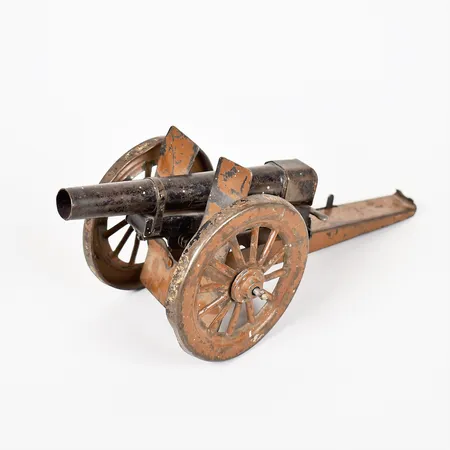 Leksakskanon, bemålad plåt, 1900-talets första hälft, höjd 10,5cm, bruks- och åldersbetingat slitage. 