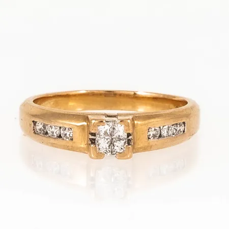 Ring i 18K guld med diamanter, 6 x 0,025ct briljantslipade, 4 x 0,02ct prinsesslipade. Den är i storlek 16, är 2 - 4,1 mm bred och väger 3,6g. Stenstorlek 0,23ct ingraverad. Stämplad GHA, 750.