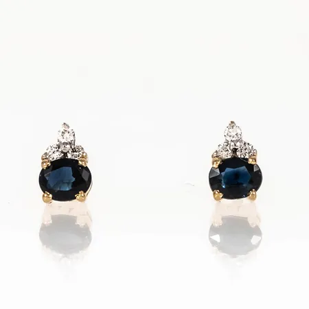 Örhängen i 18K guld med blå safirer 4,8 x 3,8 mm och 6 x ca 0,015ct briljantslipade diamanter. Mått 7,3 x 4,8 mm. Vikt: 2,7g. Framstår oanvända. 