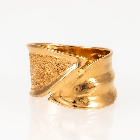 Ring i 18K guld med matt och blank yta. Den är i storlek 16¾, är 8,2 - 11,5 mm bred och väger 2,4g. Stämplad CGH, 750.