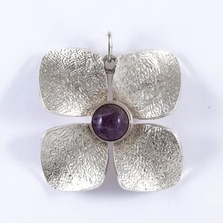 Hänge, Blomma i silver med ametist. Det är 32 mm brett, 35 mm långt inkl. ögla och väger 13,0g. Stämplad V9 (1971), VJ (Victor Janson Guldvaru AB, Lindesberg), silver & kattfot.