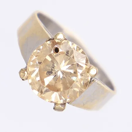 Ring med gulbrun sten, stl 18, bredd 4-10mm, påtagligt slitage, bucklig, missfärgad, limrester i fattning, nagg på sten, borrhål i sten, 18K Bruttovikt: 6,3g Vikt: 6,3 g