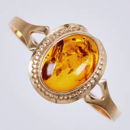 Ring med Bärnsten, stl ca 17¼, bredd ca 1-10mm, mindre buckla i fattning, 18K  Vikt: 0,9 g