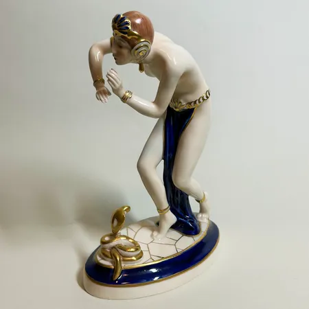 Porslinsfigurin, Ormtjuserska, från Royal Dux, Tjeckoslavakien, 1900-talets första hälft, höjd 23,5cm, flöjt saknas, ormen limmad Vikt: 0 g Skickas med postpaket.
