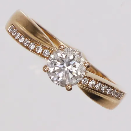 Ring, briljantslipade diamanter 1 x ca 0,65ct TCr/VS1 + 16 x ca 0,005ct, stl 16½, bredd 2-5,5mm, 18K Vikt: 4,3 g
