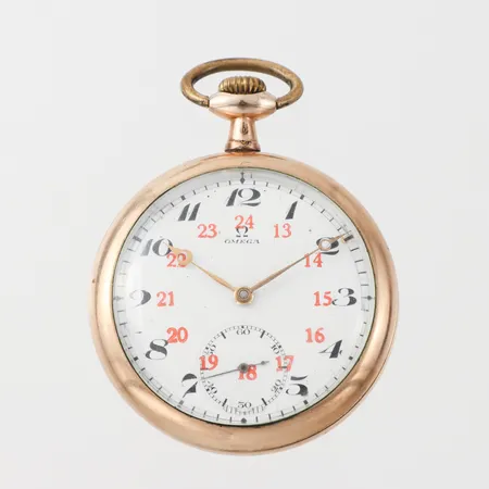 Fickur Omega med röda innersiffror, diameter ca 50 mm, tickar igång men ej funktionstestad, någon ojämnhet, gulmetall.