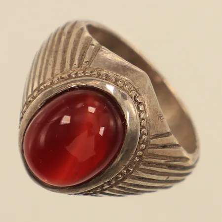 Ring med sten, troligen cabochonslipad karneol, stl 18¾, bredd ca 5-18mm, otydligt stämpel  Vikt: 11,6 g